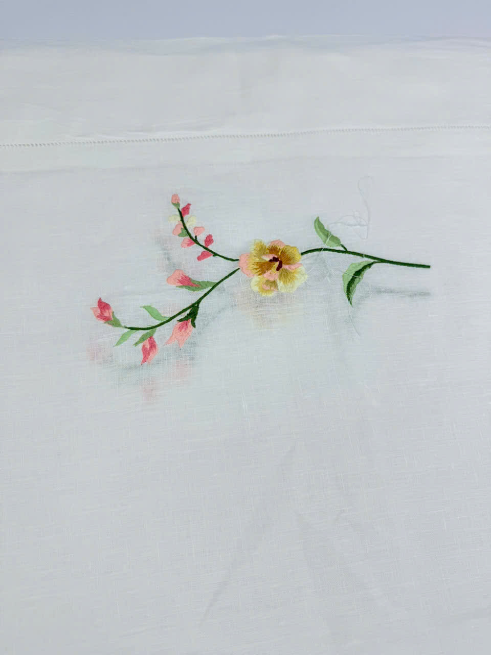 Khăn trải bàn bằng vải lanh trắng với nhánh mẫu đơn